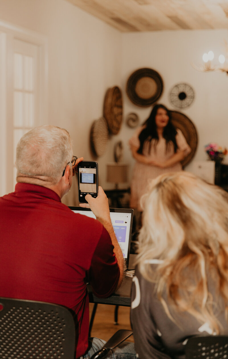 An audience member photographing Tiffany King during a speaking session